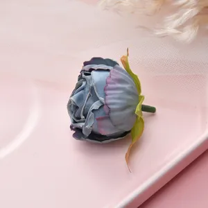 Close-up detail of artificial fabric flower head in dusty blue, perfect for DIY crafts and decor.