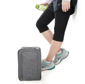Dettaglio borsa scarpe viaggio grigia portatile con chiusura zip e maniglia comoda.