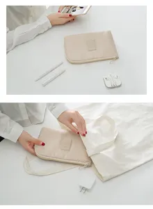 Detalle de bolsa organizadora de viaje beige con textura de tela fina y diseño compacto.