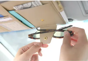 Vista detallada del organizador de parasol de coche beige con clip para gafas y ranuras.