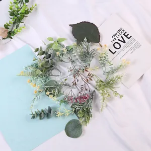 Detalle de hojas de plantas verdes artificiales, ideal para la disposición de accesorios de utilería.