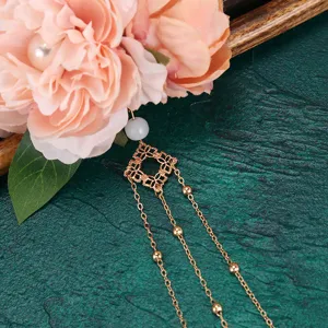 Close-up detail of Chinese style faux flower hair clip with dangling gold chains and pearls.