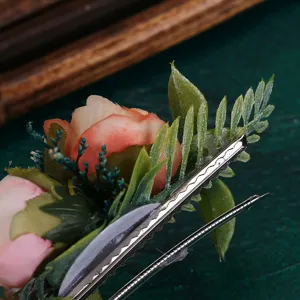 Close-up view of the elegant artificial rose hair clip with green leaves and metal spring clip.