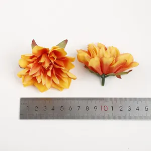 Nahaufnahme von künstlichen orangefarbenen Dahlienblüten mit praktischem Größenmessstab.
