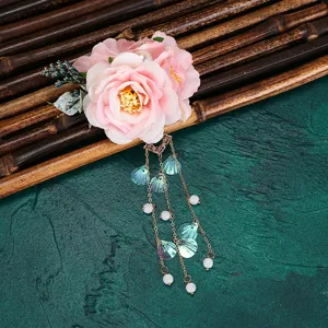 Close-up detail of the pink floral hanfu hair clip with dangling tassel and shell charms.