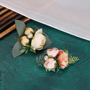 Close-up detail of artificial floral hair clip with pearls and green leaves for decoration.