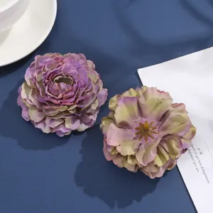 Close-up detail of artificial fabric peony flower heads with purple green gradient petals.