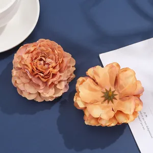Close-up detail shot of peach orange satin fabric peony flowers, craft floral accessory.
