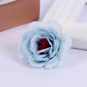 Close up view of light blue artificial rose flower head showing detailed silk petals and stamen.