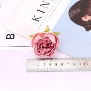 Artificial rose flower head detail shot, pink silk floral decor prop for home and wedding crafts.