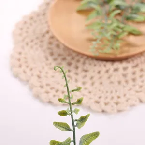 Primer plano detallado de hojas de plantas artificiales, ideal para utilería y decoración.