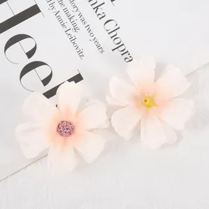 Close-up detail of artificial silk flower heads featuring delicate pink petals for DIY crafts.