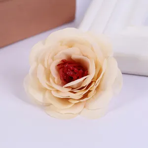 Close-up detail of artificial champagne rose flower head with vibrant red center for decor.