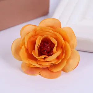 Close-up view of artificial orange rose flower head showing detailed fabric petals and rich color.