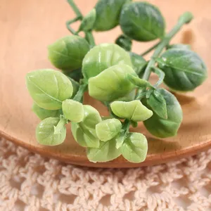 Detalle de hojas de plantas verdes artificiales, ideal para arreglos florales y accesorios de atrezo.