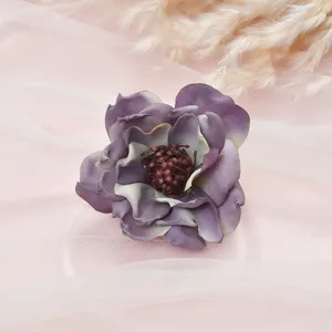 Close-up detail of a purple artificial peony silk flower head, soft fabric texture for decor.