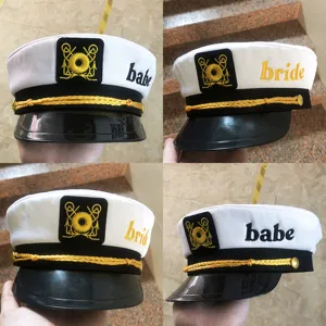 Classic white sailor hat featuring stylish gold rope trim and embroidered letter details.