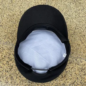 Detail view of black flat top military cap interior lining, cotton cadet hat structure.