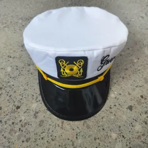 Details of the white cotton sailor hat featuring gold anchor embroidery and groom text detail.