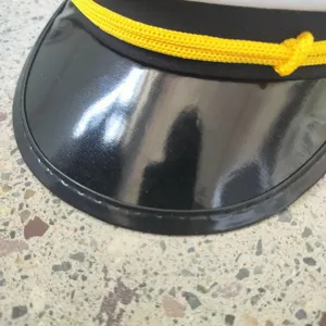 Detailed close-up of a black sailor hat visor with decorative yellow braided rope.