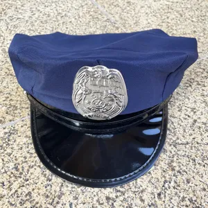 Close-up detail of the blue costume police hat with shiny black brim and silver badge.
