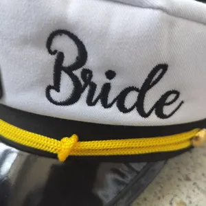 White bride captain hat with black brim and yellow braided rope detail party headwear