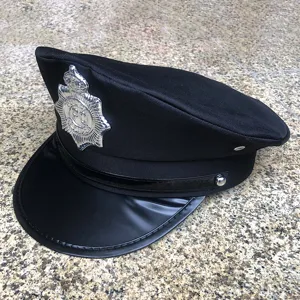 Detalle de gorra de policía negra, corona de tela texturizada, visera brillante y insignia.
