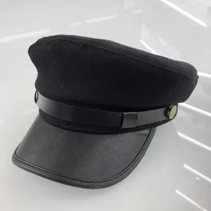 Classic black wool blend newsboy cap with leather visor and chic metal button detail.