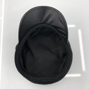 Detailed view of the black cadet cap showing its smooth leather visor and fine interior lining.