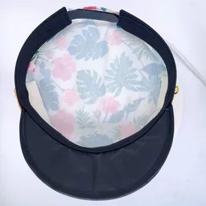 Detailed view of tropical leaf print sailor hat inside, black brim yacht party cap design.
