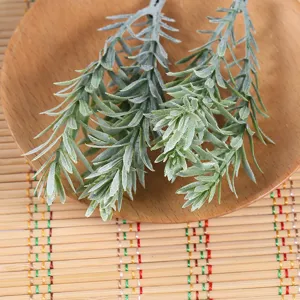 Artificial green leaves detail close-up, faux foliage plant branch for wedding flower arrangement.