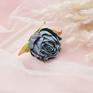 Close-up detail of blue artificial flower head on pink mesh fabric with pampas grass decor.