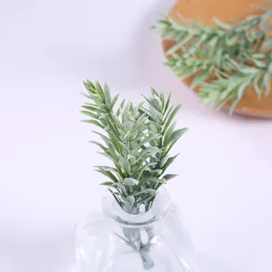 Detailed closeup of artificial green leaves in a glass bottle, perfect for home decor and floral.