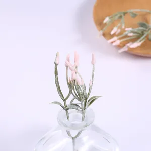 Detailed view of artificial pink floral stems in a clear glass bottle for home decoration.