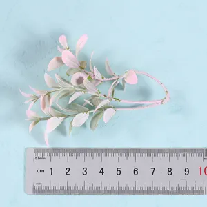 Artificial eucalyptus leaves branch detail view, pink plant decor for home, wedding or party.