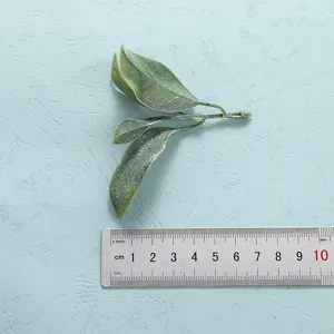 Artificial green plant leaves branch detail close-up showing realistic texture and size scale.