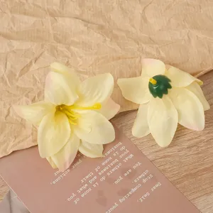 Nahaufnahme künstlicher gelber Lilienblütenköpfe mit grünem Boden für Bastelarbeiten.