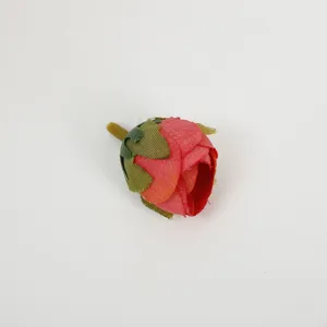 Close-up detail of artificial red rose flower bud, fabric floral accessory for DIY crafts.