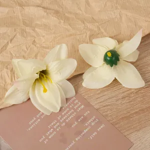 Detailaufnahme künstlicher weißer Lilienblüten für Bastelarbeiten, Haarschmuck und florale Deko.