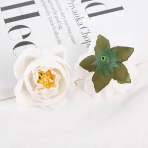 Detail shot of artificial white rose flower heads, showing front petal layers and green calyx back.