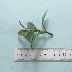 Close-up detail of artificial leaf branch showing realistic texture and size for decoration use.