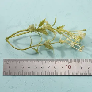 Detailed close-up shot of artificial green plant stem with small leaves for home decor.