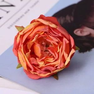 Close-up detail of artificial red orange rose flower head, perfect home decor photography prop.