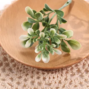 Detalle de rama de hojas de plantas verdes artificiales, ideal para accesorios de fotografía.