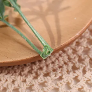 Primer plano detallado de tallo y hoja de planta artificial para arreglos florales y manualidades.