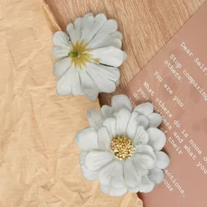 Artificial daisy flower heads detail view, fabric material for DIY crafts and accessories.