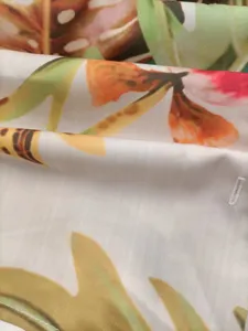 Detail view of the floral printed fabric, showing vibrant tropical leaf patterns and fine stitching.