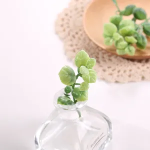 Hojas de plantas verdes artificiales en botella de vidrio decoración fotografía oficina