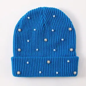 Detailed view of women's blue knit beanie featuring delicate pearls and sparkling rhinestones.