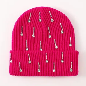 Close up of bright pink knit beanie featuring sparkling rhinestone teardrop decorations.